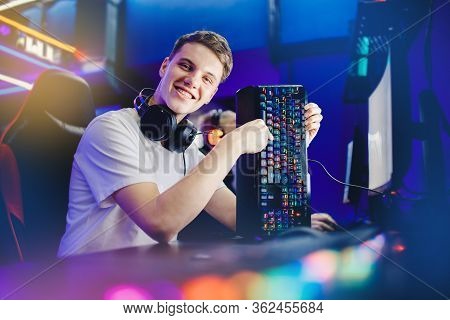 Professional Young Man Player In Online Video Game Cybersportsman Advertises Headphones, Keyboard An