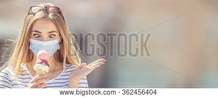 Beautiful Girl Wearing A Face Mask Looking Down At An Ice Cream In Her Hand With A Cross-eyed Look A