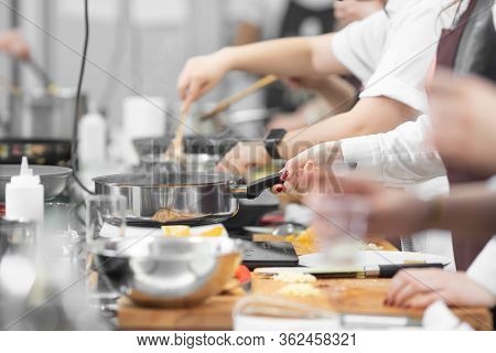 Background Cook Leads Master Class In Cooking In Kitchen