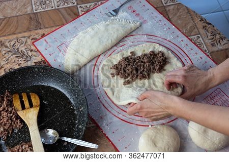 Close Up Of A Woman's Hands Making Dough For Homemade Bread On A Silicone Baking Sheet. Frying Pan W