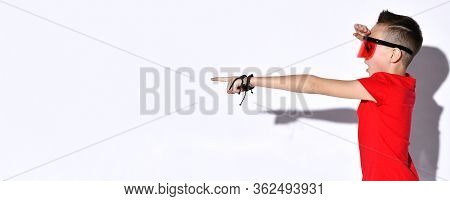 Teenage Child In Oversized Sunglasses With Protective Visor, Red T-shirt And Black Bracelets. He Is 