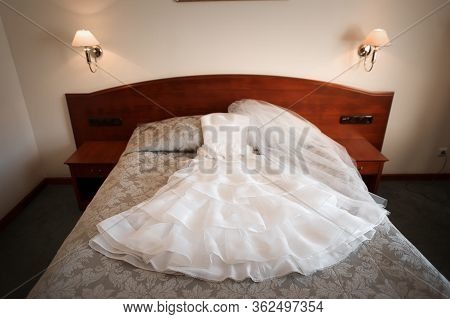 Wedding Dress Is Beautifully Laid Out On The Bed In The Hotel Room