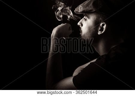 Sepia Side View Portrait Of Cute Young Guy With Moustache And A Hat On Black, Dark Background Smokin