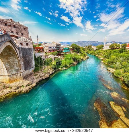 Fantastic Skyline Of Mostar With The Mostar Bridge, Houses And Minarets, During Sunny Day. Location: