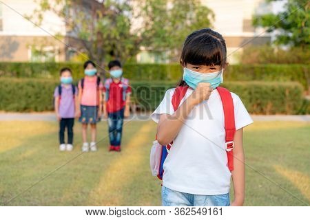 Asian Girl Preschool Child Student Wearing Healthy Face Mask Sneeze With Friends In Background. Who 