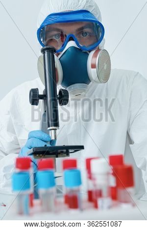 COVID-19. Doctor, microbiologist, scientist in a protective suit, makes a study of coronavirus in the laboratory. Coronavirus test.