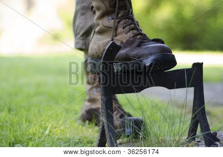 A Walker Cleaning The Soles  Of Walking Boots On An Old Cast Iron Boot Scraper.