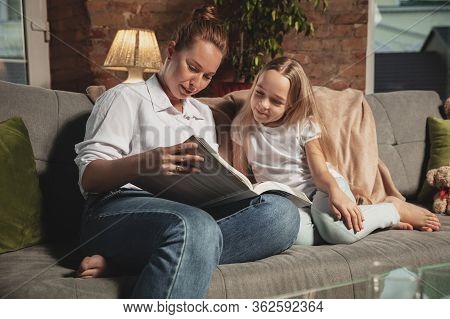 Reading Book. Mother And Daughter During Self-insulation At Home While Quarantined, Family Time Cozy