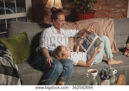 Book Reading. Mother And Daughter During Self-insulation At Home While Quarantined, Family Time Cozy