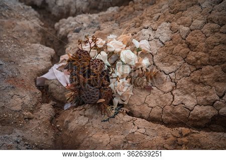Wedding Decorations. A Wedding Bouquet Of Dried Lotuses And Roses Lies On Clay. Beautiful Bouquet Fo