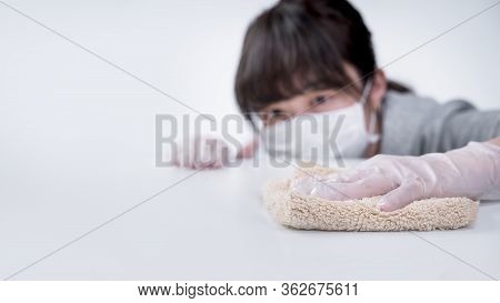 Young Woman Housewife Is Cleaning, Wiping Down Home Table Surface To Stop The Spread Of Infection Wi
