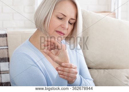Woman Massaging Her Arthritic Hand And Wrist