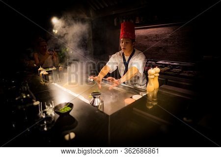 May, 2018 - Ari Atoll, Maldives: Happy Teppanyaki Chef Cooking Vegetables At Teppan In A Japanese St