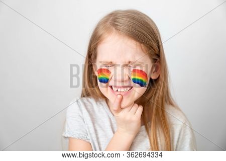 Kid With Blond Hair And Painted Cheeks A Rainbow. Stay Home. Flashmob Chasetherainbow.