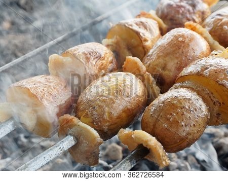 Potato On A Skewer. Vegetarian Kebab. Potato With Bacon Cooking On Charcoal.