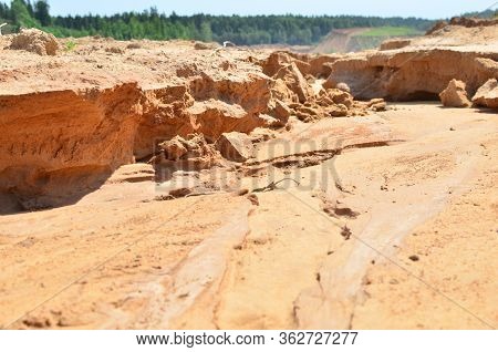 Background Of Yellow Sand With Small Stones After Rain. Soil Erosion After Heavy Rainfall And Precip