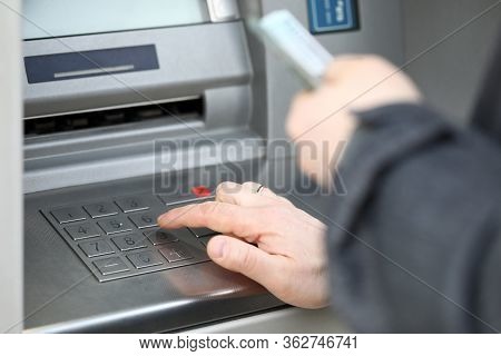 Close-up Of Man Pressing Pin Code On Cash Machine Outdoors. Person Getting Salary Or Pension. Credit