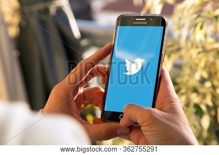 Rosario, Argentina - August 8, 2017: Girl With Smartphone In Her Hands And A Twitter Logo On The Scr