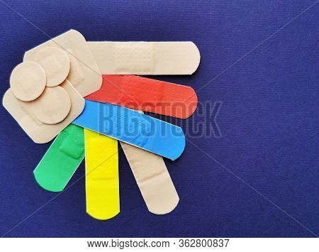 Colored Adhesive Plaster On A Dark Blue Background. Colorful Bandages.