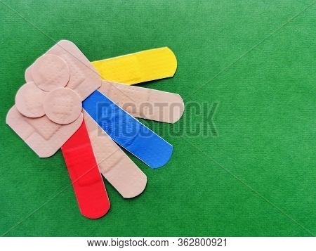 Colored Adhesive Plaster On A Green Background. Colorful Bandages.