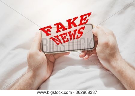 Fake News Infodemics During Covid-19 Pandemic Concept. Man Hands Holding Mobile Phone Reading Global