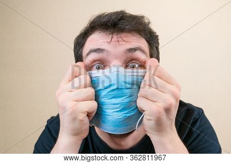 Young Man In Blue Protective Medical Mask And Happu With It. Self-isolation And Quarantine. Stay Hom