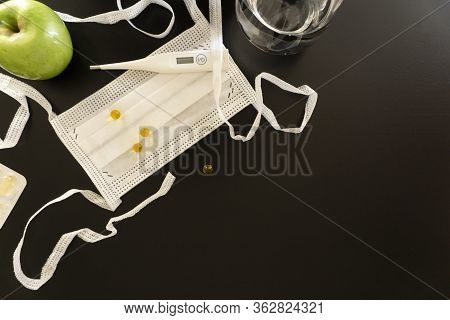 White Medical Objects Located In A Corner On A Dark Background, A Protective Medical Mask With Ties,