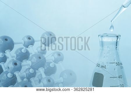 Glass Flask With Water Drop In Blue Medical Sciene Laboratory With Molecular Chemistry Model Backgro