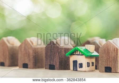 Green House In Among Wooden House For Real Estate. Planning Savings Money Of Coins To Buy A Home Con
