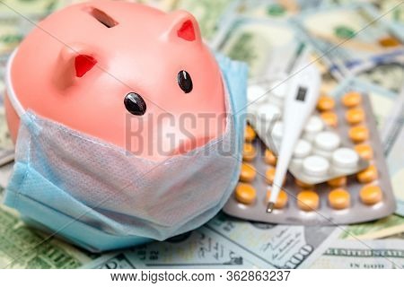 Piggy Bank In A Mask On A Background Of American Currency.the Concept Of Coronavrius Epidemic