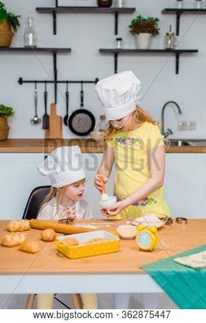 Family Scene At Home - Two Cute Lettle Sisters Happily Baking Cookies And Buns