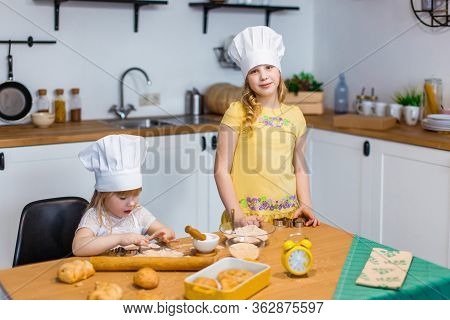 Family Scene At Home - Two Cute Lettle Sisters Happily Baking Cookies And Buns