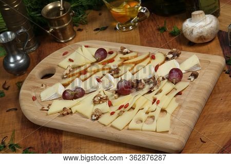 Wooden Plateau With Fresh Grapes Figs And Types Of Cheese Closeup As Homefood Background