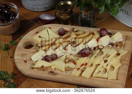Wooden Plateau With Fresh Grapes Figs And Types Of Cheese Closeup As Homefood Background