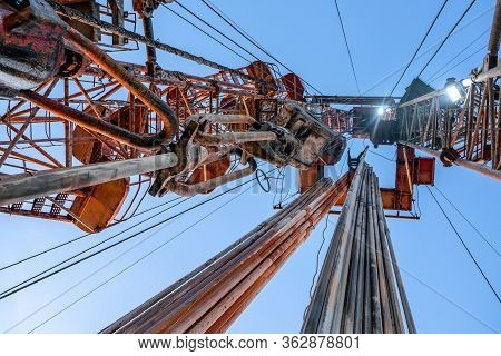 Oil And Gas Drilling Rig Onshore Dessert With Dramatic Cloudscape. Oil Drilling Rig Operation On The