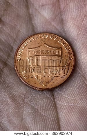American Us Coin 1 Cent Penny Lies On A Dirty Palm Close Up. An Impressive, Dramatic Vertical Shot W