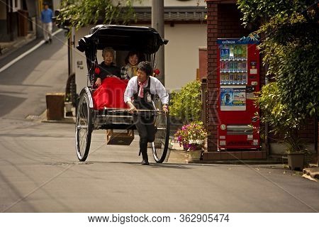 Kyoto, Japan - May 9: Two Women In A Rickshaw Pulled By A Young Tour Guide On A Street In Kyoto, Jap