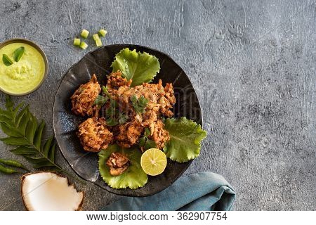 Indian Cuisine. Pakora Traditional Indian Deep-fried Snack. Pakoras On Black Plate With Coconut Chut