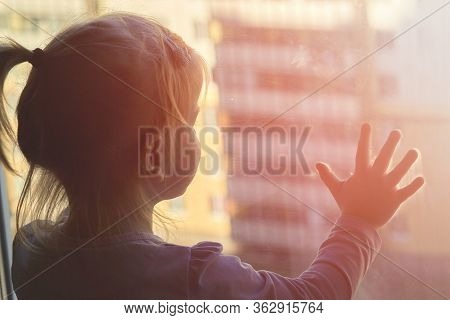 Girl Looks Lonely Through Window By Putting Her Hands On Window Sill
