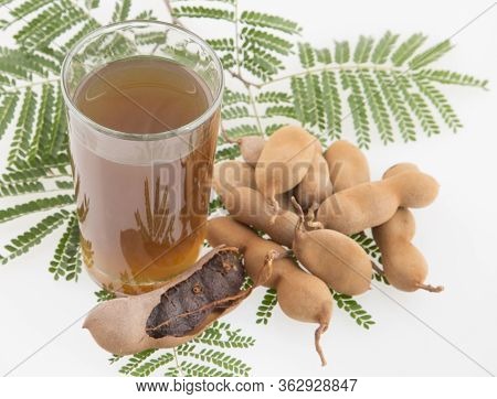 Tamarind Juice In A Glass Surrounded By Fresh Ripe Tamarinds - Tamarindus Indica