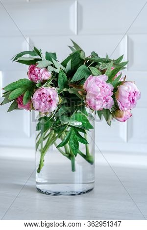 Bouquet Of Pink Peonies In Glass Vase Against White Background And Wooden Table. Mothers Day Card. B