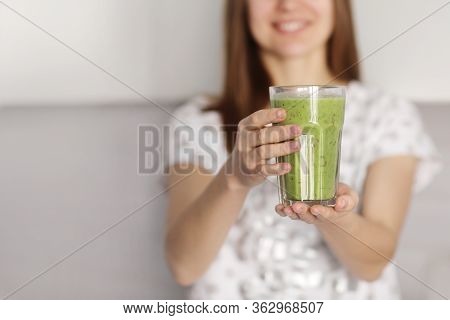 Eautiful Girl Drinks Freshly Prepared Smoothie In Kitchen. Smoothies Freshly Made From Assorted Vege