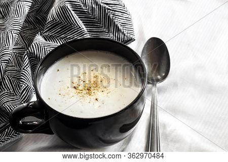 Cauliflower Soup (creme Du Barry) In Black Bowl On White Background With Black And White Cloth. Copy