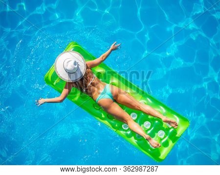 Woman on a lilo at the swimming pool