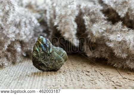 Closeup Of Rough Uncut Labradorite Gem In Rock Form On Wooden Background. Colorful Flashes Of Labrad