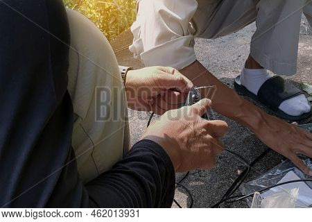 Technician Repairing Broken Fiber Optic Cable Outdoors On Site
