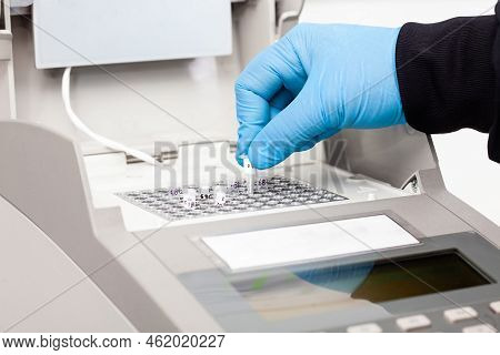 Closeup Of A Scientist Hand While Working At The Laboratory With A Thermal Cycler. Polymerase Chain 