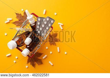 Disease Concept. Top View Photo Of Shopping Cart With Remedy Spray And Syrup Transparent Brown Bottl