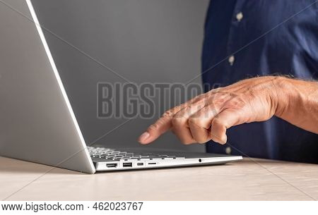Man Forefinger Pressing Keyboard Button At Laptop. Male Using Computer For Work, Study Or Leisure Wh