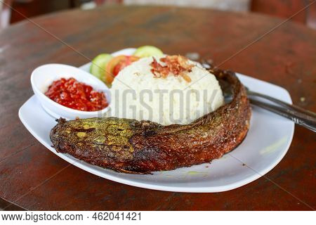 Indonesian Special Food. Close Up Pecel Catfish Served On A White Plate Placed On A Wooden Table